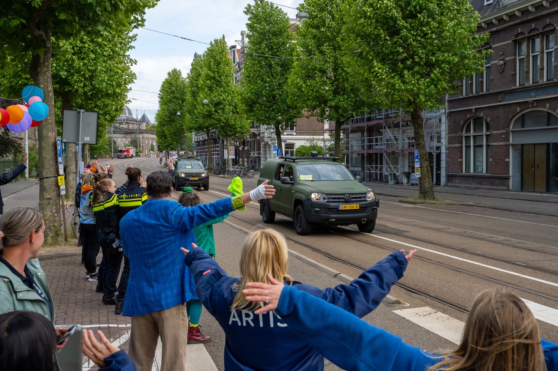 Vrijwilligers van het kinderbeestfeest halen zwaaiend hulpvoertuigen binnen